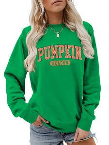 Détail du lettrage vintage Pumpkin Season orange sur un sweat à col rond vert