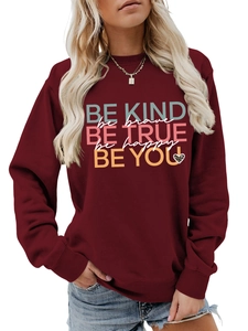 Close-up of burgundy sweatshirt with leopard heart and 'Be Kind' motivational text