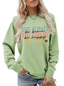 Detail of light green crewneck sweatshirt featuring colorful 'Be Kind' printed lettering