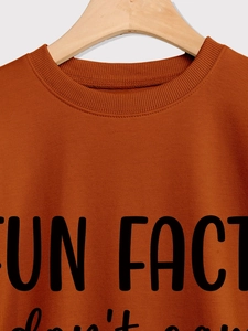 Detail of caramel crewneck sweatshirt with Fun Fact text print on cotton fabric