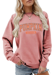 Détail du col rond côtelé et de l'imprimé Pumpkin Season sur un sweat-shirt rose