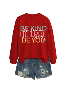 Detail of red sweatshirt with inspirational colorful quotes and frayed denim shorts