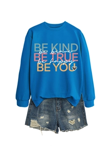 Detail of blue crewneck sweatshirt with BE KIND text and leopard print heart graphic