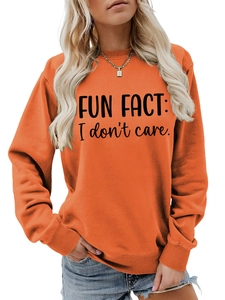 Close-up of bright orange crewneck sweatshirt with Fun Fact I Don't Care slogan print