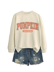Mise à plat du sweat Pumpkin Season crème et d'un short en jean bleu délavé usé
