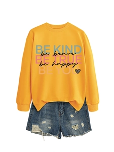 Orange crewneck sweatshirt with 'Be Brave' graphic and leopard heart detail next to denim shorts