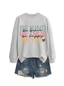 Flat lay of gray crewneck sweatshirt with colorful motivational quotes and denim shorts