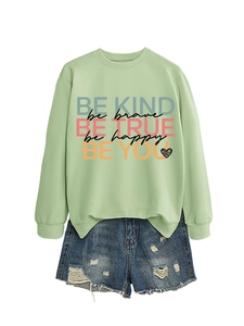 Detail of light green sweatshirt with inspirational quotes and distressed denim shorts