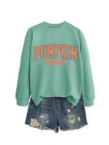 Mise à plat d'un sweatshirt Pumpkin Season vert menthe et d'un short en jean déchiré