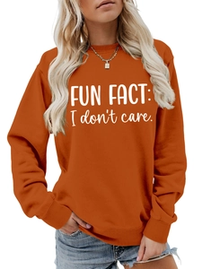 Detail of caramel orange crewneck sweatshirt featuring white Fun Fact slogan print