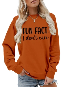 Detail of ribbed crewneck and 'FUN FACT: I don't care' slogan on orange sweatshirt