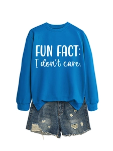 Detail of blue crewneck sweatshirt with 'FUN FACT: I don't care' text and ripped denim shorts