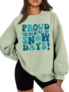 Detail of sage green sweatshirt featuring blue Proud Supporter Of Snow Days graphic print