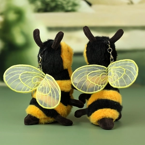 Detail of plush bee keychain with soft faux fur texture and gold metal lobster clasp