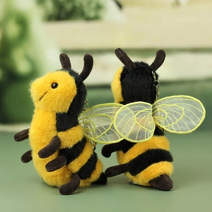 Detail of plush bee keychain showing soft yellow and black fur with mesh wings
