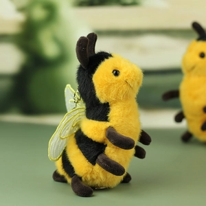 Detailed close-up of plush bee keychain featuring embroidered lace wings and gold hook