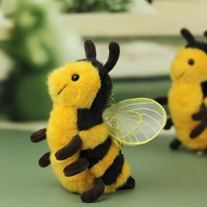 Detailed macro view of plush bee keychain with fuzzy texture and golden mesh wings
