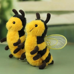 Close-up of cute plush bee charms with fuzzy yellow fur and gold mesh wings details