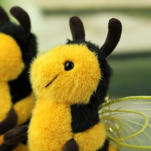 Macro detail of plush bee pendant featuring golden mesh wings and soft yellow texture