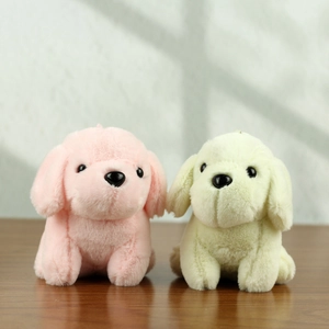 Dettaglio di portachiavi a forma di cane in peluche rosa e beige su superficie in legno