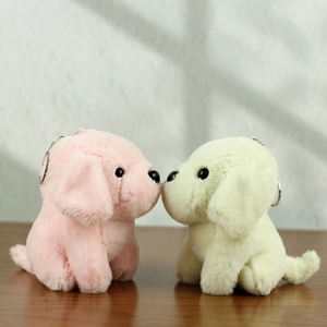 Dettaglio di due simpatici portachiavi a forma di cucciolo in peluche rosa e giallo