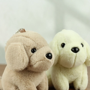 Dettaglio dei portachiavi a cucciolo di peluche marrone e crema con ganci metallici
