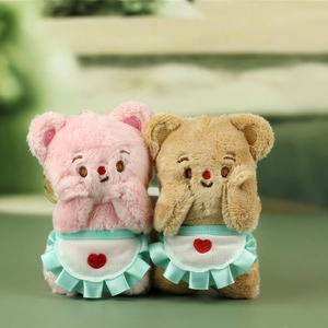 Detailed close-up of pink and brown plush bears with blue aprons and heart embroidery