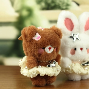 Close-up of plush bear and bunny charms with pearl dresses and metallic heart details