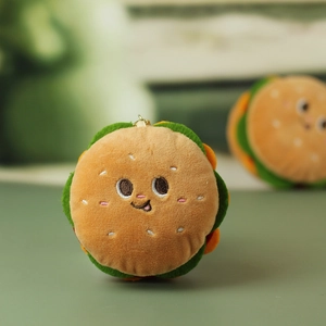Dettaglio del ciondolo a forma di hamburger in peluche con ricami morbidi e curati