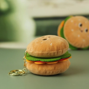 Dettaglio macro di un portachiavi a forma di hamburger in peluche con viso ricamato