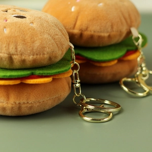Dettaglio ravvicinato di portachiavi a forma di hamburger in peluche con ganci dorati