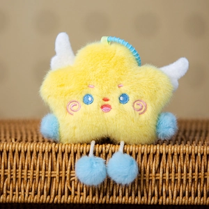 Detail of yellow plush star pendant with blue pom-pom limbs and white wings on rattan