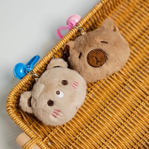 Detalle de colgantes de peluche de animales en una cesta con ganchos de colores