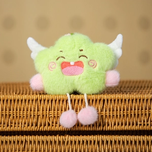 Close-up of green star plush charm with embroidered smile and white wings on a basket