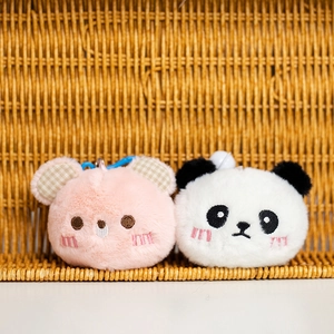 Detalle de llaveros de peluche panda y conejo rosa con piel suave y gancho azulado