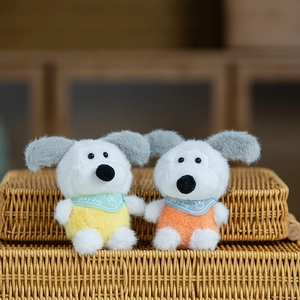 Ciondoli per cani in peluche gialli e arancioni con sciarpe su cesto di vimini