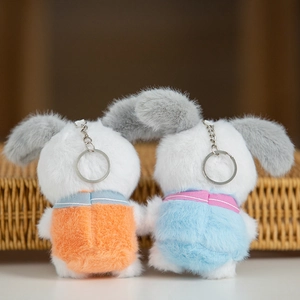 Vista posteriore di due portachiavi a forma di coniglio in peluche con salopette