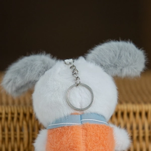 Dettaglio del portachiavi cucciolo di peluche con pelliccia tricolore e anello in metallo