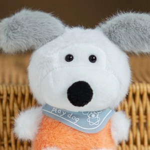 Dettaglio di cane di peluche con bavaglino blu stampa Play Dog e maglione arancione morbido