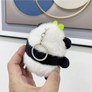Close-up of a fluffy panda plush keychain with a silver metal ring and green accent