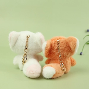 Plush fox doll keychains in cream and orange with fluffy tails and golden metal hooks