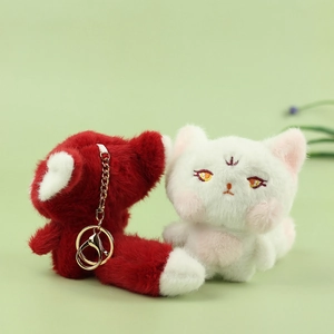 Detail of plush fox keychains with soft fur, embroidery, and gold metal hardware
