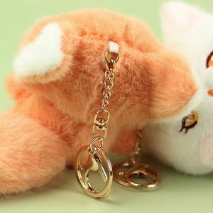 Close-up of soft plush fox keychain with high-gloss gold lobster clasp and metal ring
