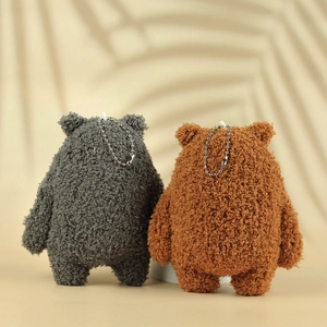 Rear view of cute plush bear charms in grey and brown showing fluffy grainy texture