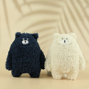 Close-up of cute plush bear charms in blue and white with soft curly faux fur texture