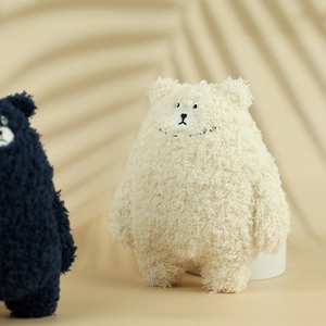 Detailed close-up of soft plush bear charms with cream sherpa fabric and fine embroidery