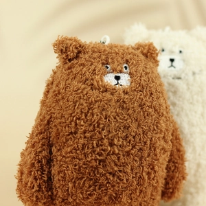 Close-up of curly brown teddy bear plush keychain with soft texture and cute face