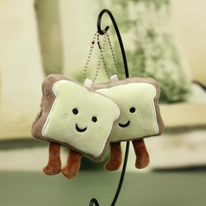 Close-up of cute plush toast bread keychain set with smiling faces and metal bead chains