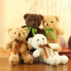 Group of soft plush teddy bears with silk scarves in brown and white on wooden surface