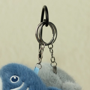 Dettaglio dell'anello portachiavi in metallo e della catena su un peluche squalo